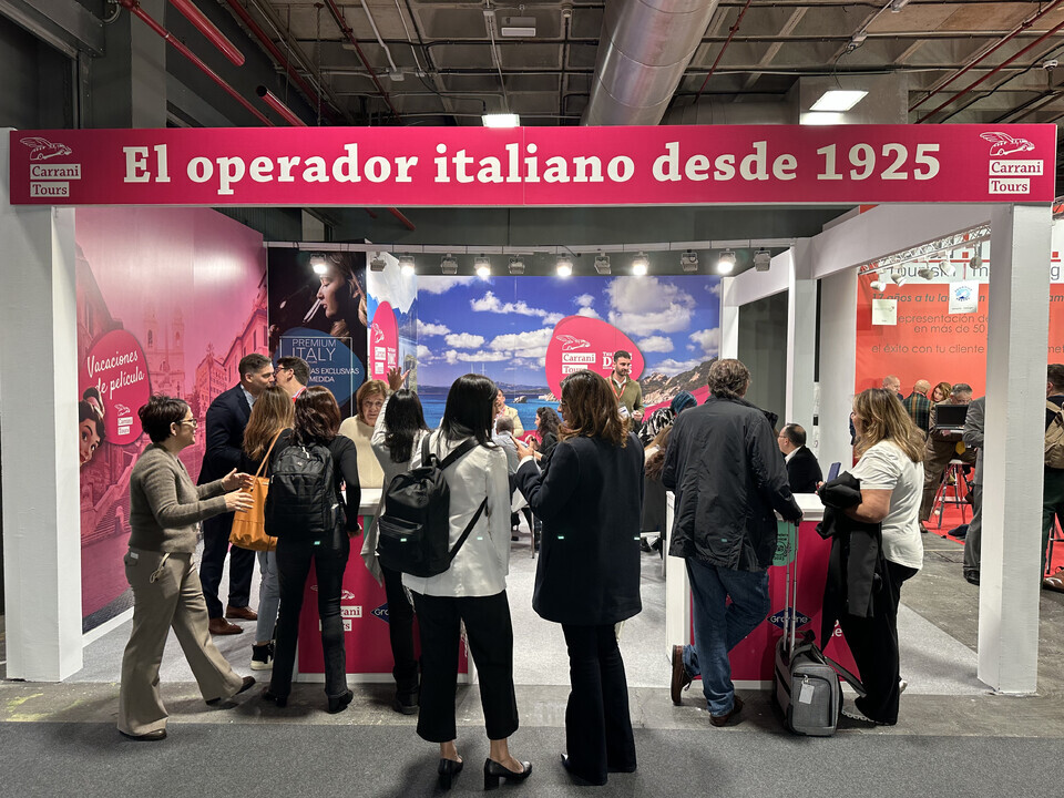 Carrani Tours booth with attendees at FITUR tourism trade fair in Spain, showcasing "The Italian operator since 1925".
